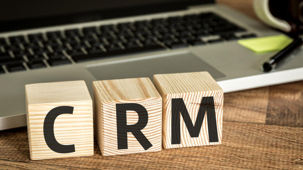 Cubos con las letras CRM frente a un portátil: gestión de clientes