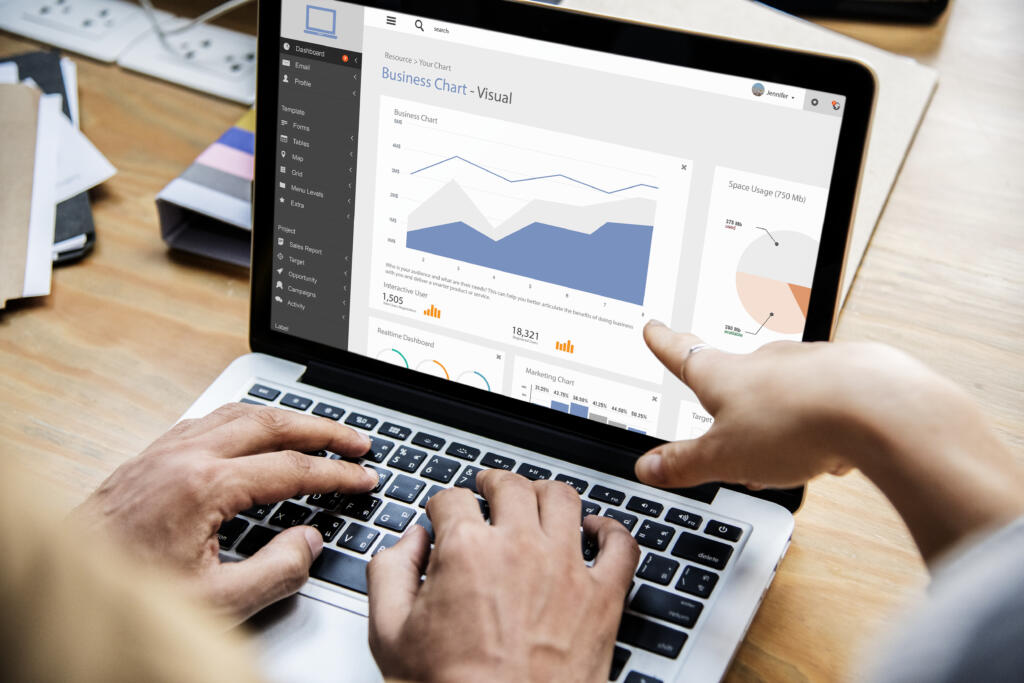 Persona analizando gráficos de datos empresariales en una laptop