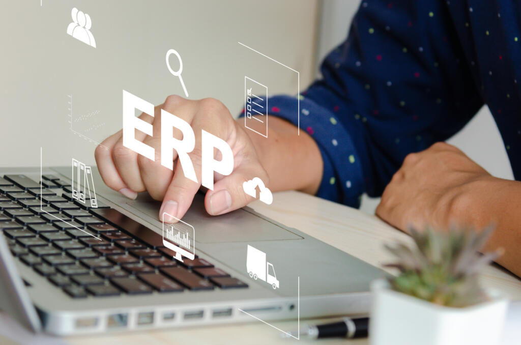 Persona usando ERP en laptop para gestión empresarial y digitalización