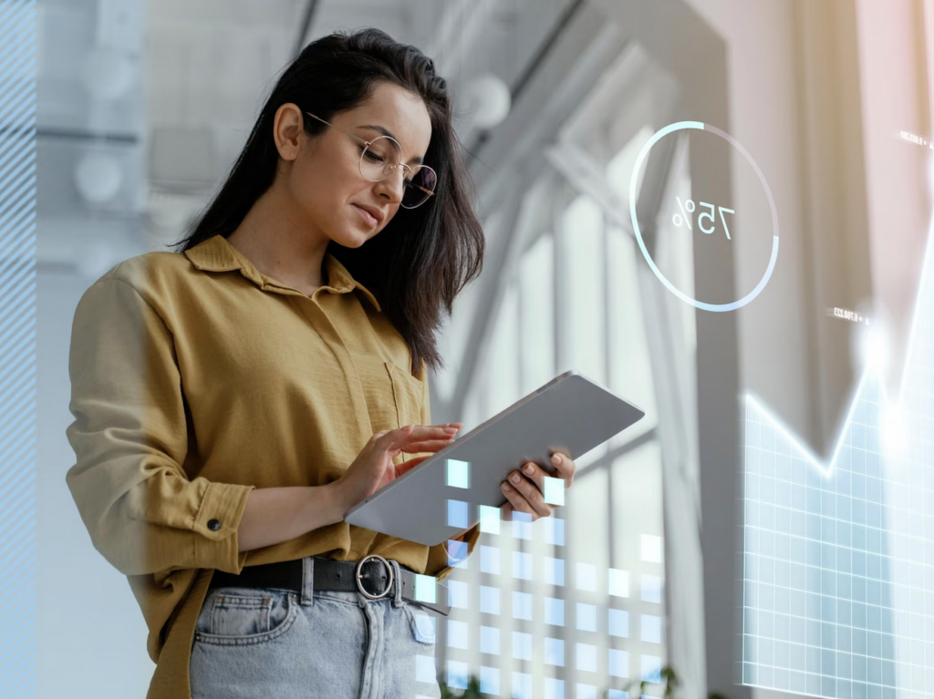 Mujer con tablet analizando estadísticas digitales en gráfico, entorno moderno de oficina.