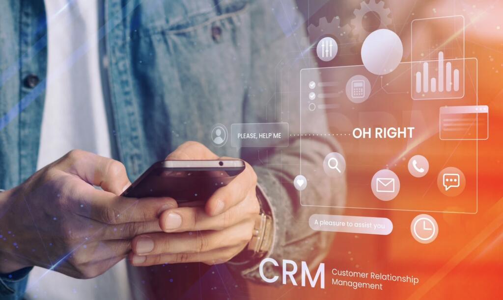 Persona con smartphone con iconos CRM y gráficos digitales: gestión de clientes